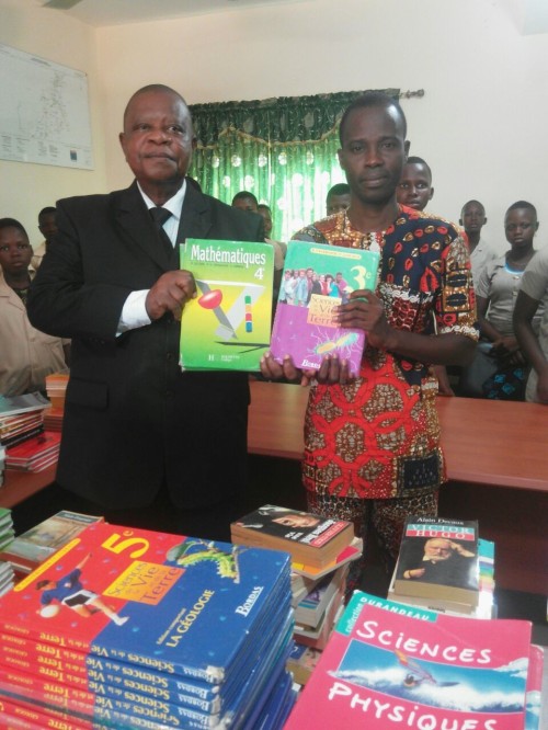 A gauche, sur la photo ci - dessous, le  Maire du village de Zogbotomey,  qui   p rés ide  cette remise de livres .